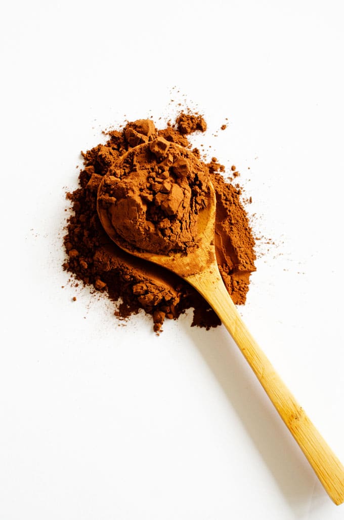 Cocoa powder on a spoon on a white background
