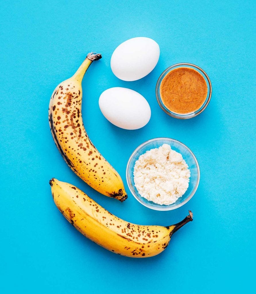 Banana, egg, and almond butter on a blue background