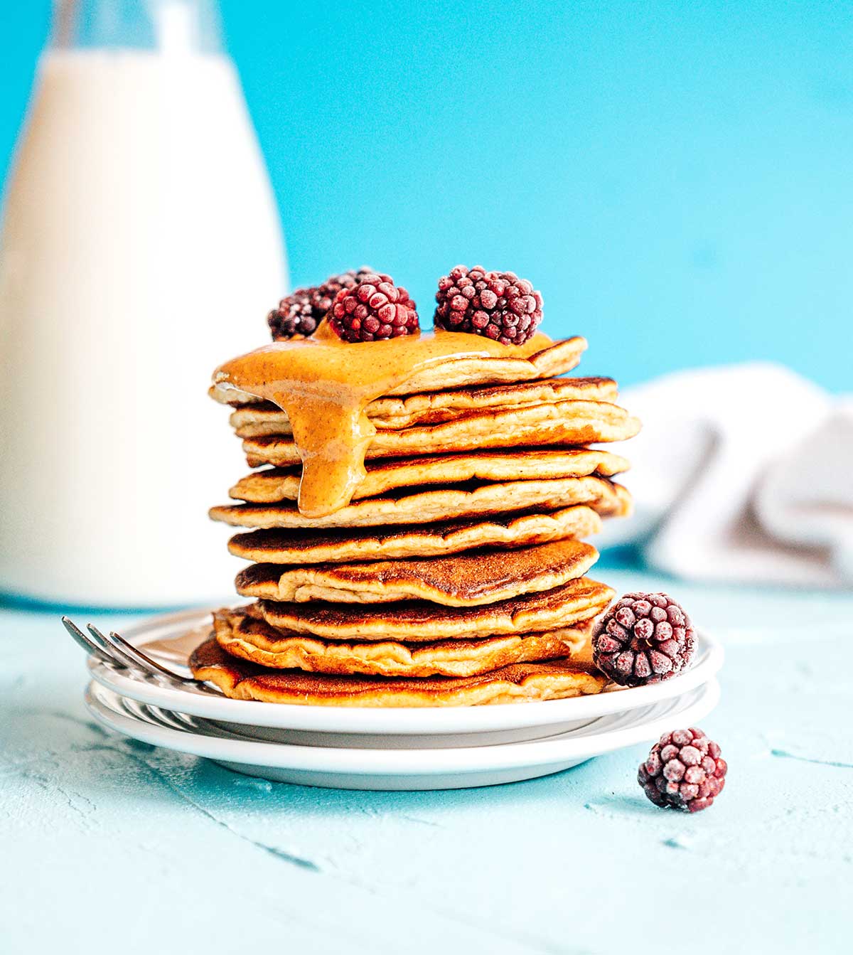 Paleo pancakes with almond butter on a blue background