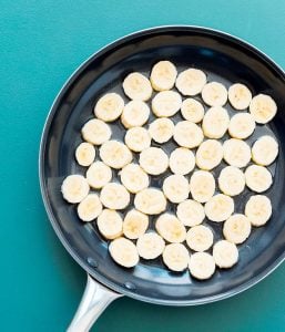 Bananas frying in a pan.