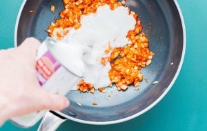 Coconut milk being added to the pan.