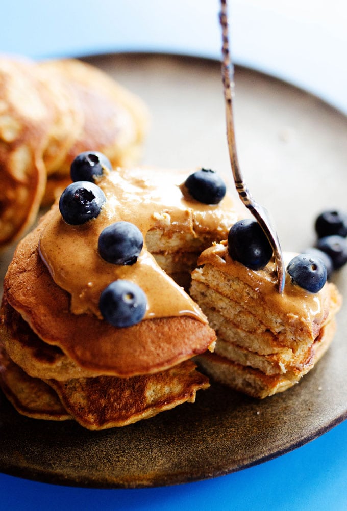 Paleo pancakes stacked with almond butter and blueberries