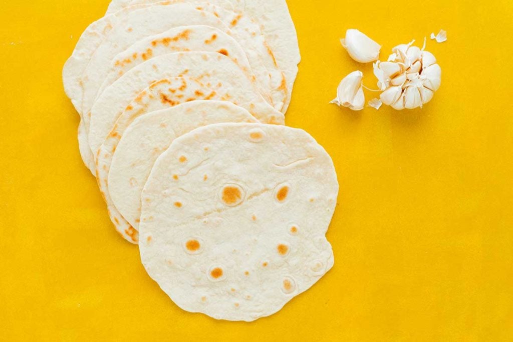 Tortillas laying with a clove of garlic