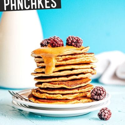 Paleo pancakes with almond butter and berries on a blue background