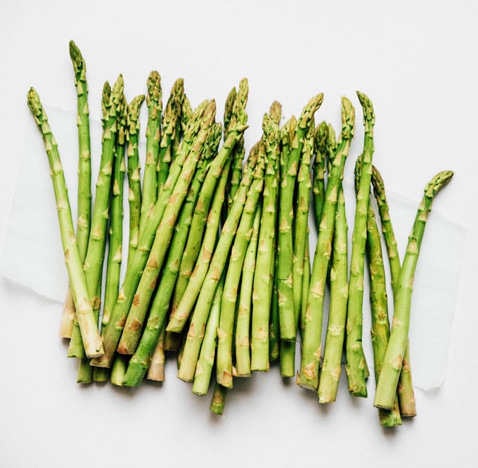 Bunch of green asparagus stalks on a gray background