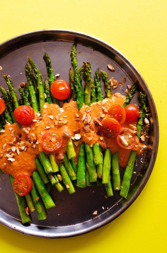 This Roasted Asparagus with Smoky Romesco Sauce is a simple, flavor-packed recipe that is sure to brighten up your dinner table with! With just 1 pan and I'm 30 minutes you’ll have a show stopping side dish ready to go.