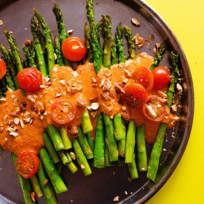 This Roasted Asparagus with Smoky Romesco Sauce is a simple, flavor-packed recipe that is sure to brighten up your dinner table with! With just 1 pan and I'm 30 minutes you’ll have a show stopping side dish ready to go.