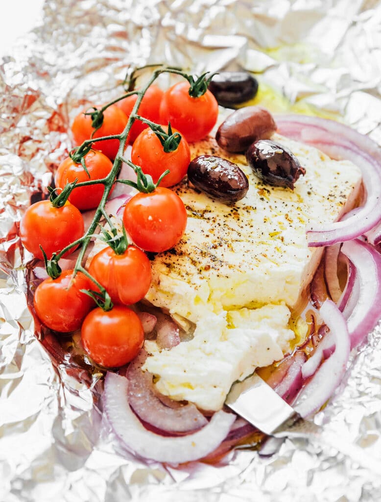 Greek baked feta cheese ingredients sitting on top of a piece of tin foil