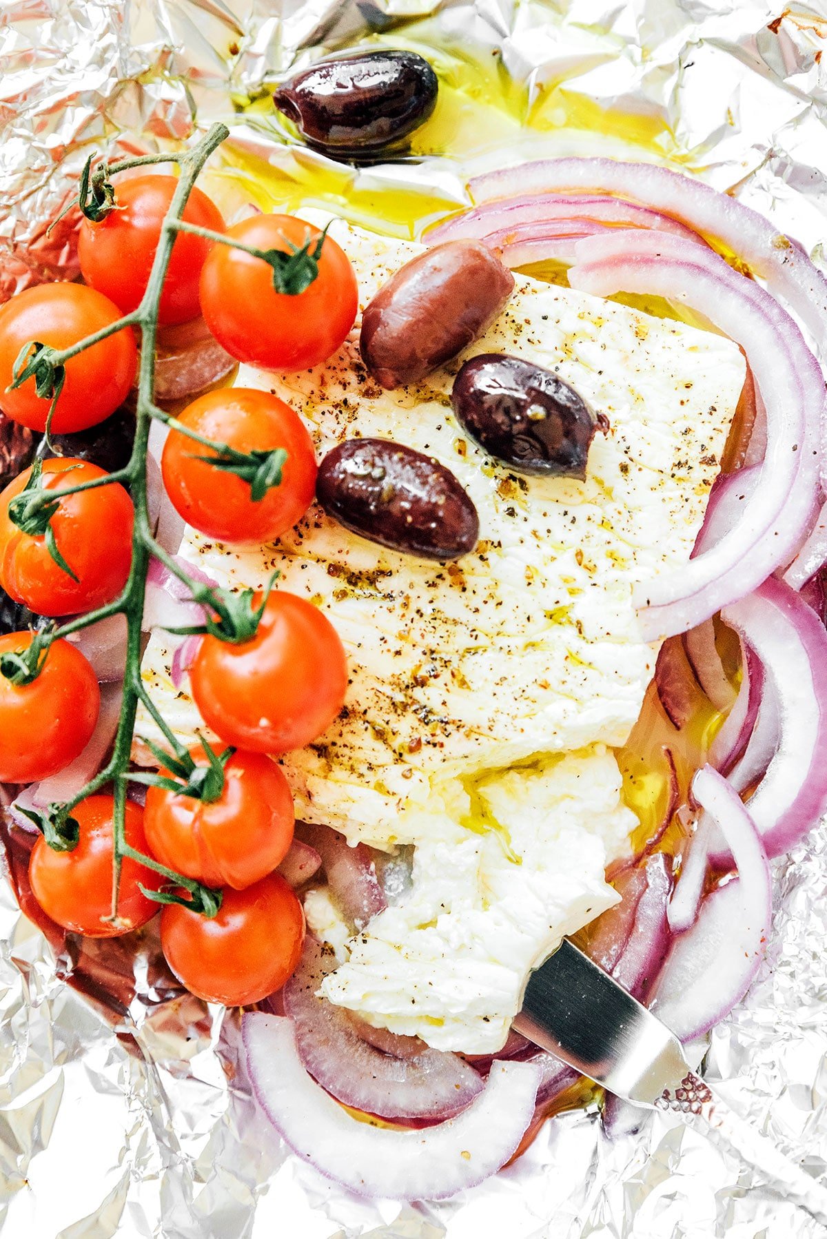 Greek baked feta ingredients sitting on top of a piece of tin foil