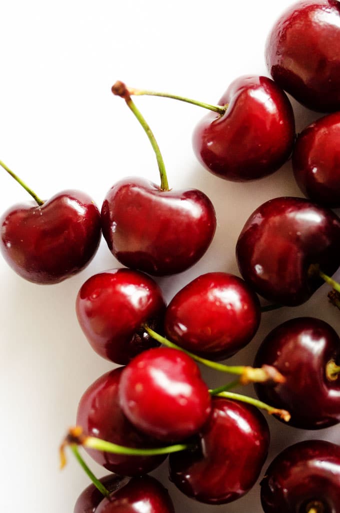 Close up photo of cherries on white background