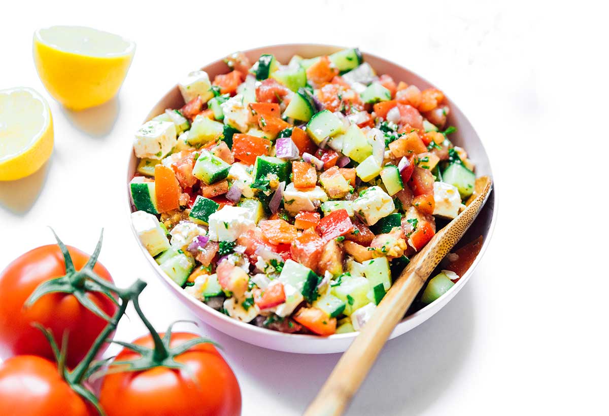 A serving dish filled with a freshly mixed summer veggie salad