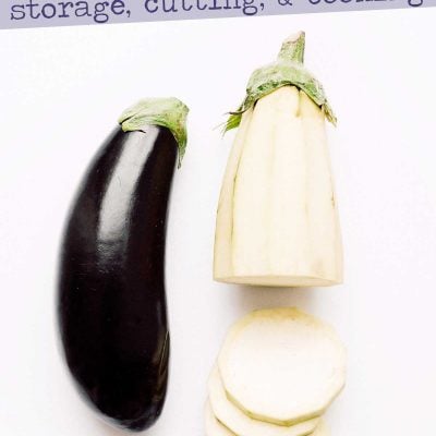 Photo of two eggplants, one peeled and sliced, on a white background