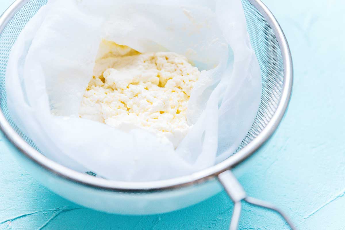 Strained ricotta cheese in a cheesecloth