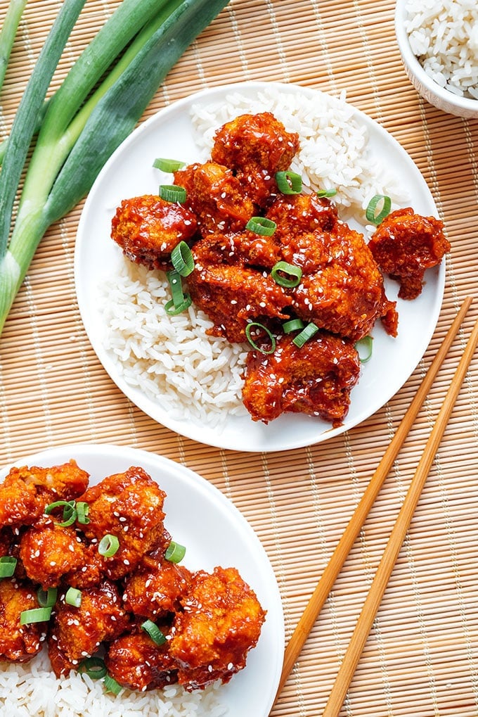 General Tso's cauliflower on a plate with rice and green onions