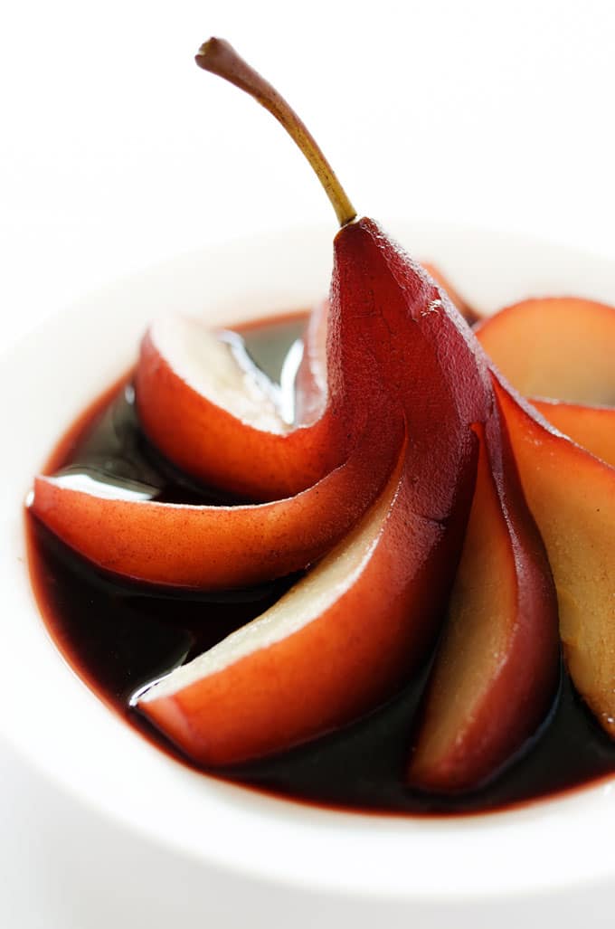 Red wine poached pears on a white background