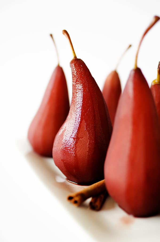 Red wine poached pears on a white background