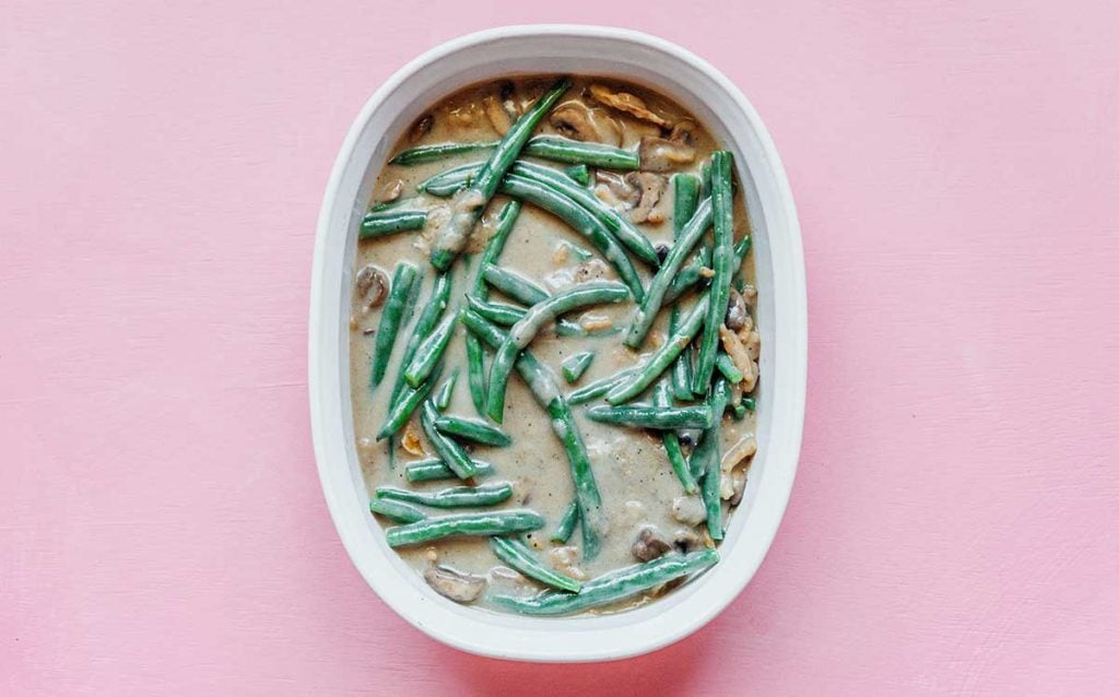 A casserole dish filled with uncooked vegan green bean casserole