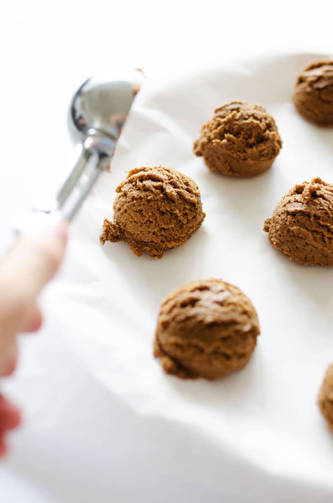 Scooping speculaas cookies onto a baking sheet
