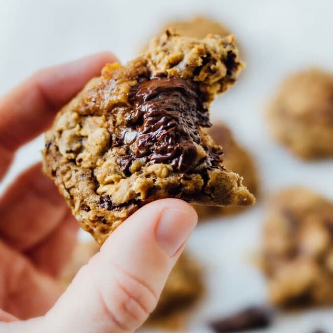 Cookie in hand - Need a healthy cookie recipe that's just as moist and delicious as your old favorites? This Sweet Potato Cookies recipe with chocolate and oats has you covered.