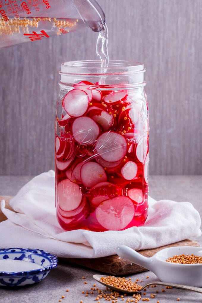 pickled red radishes in a mason jar - These radish recipes are simple and delicious (and best of all, they'll make you actually WANT to eat your veggies!) Give them a try for a colorfully peppery crunch.
