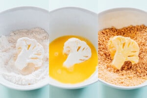 An orange cauliflower floret is coated in flour, then dipped in beaten egg, and finally covered in breadcrumbs in three separate bowls.