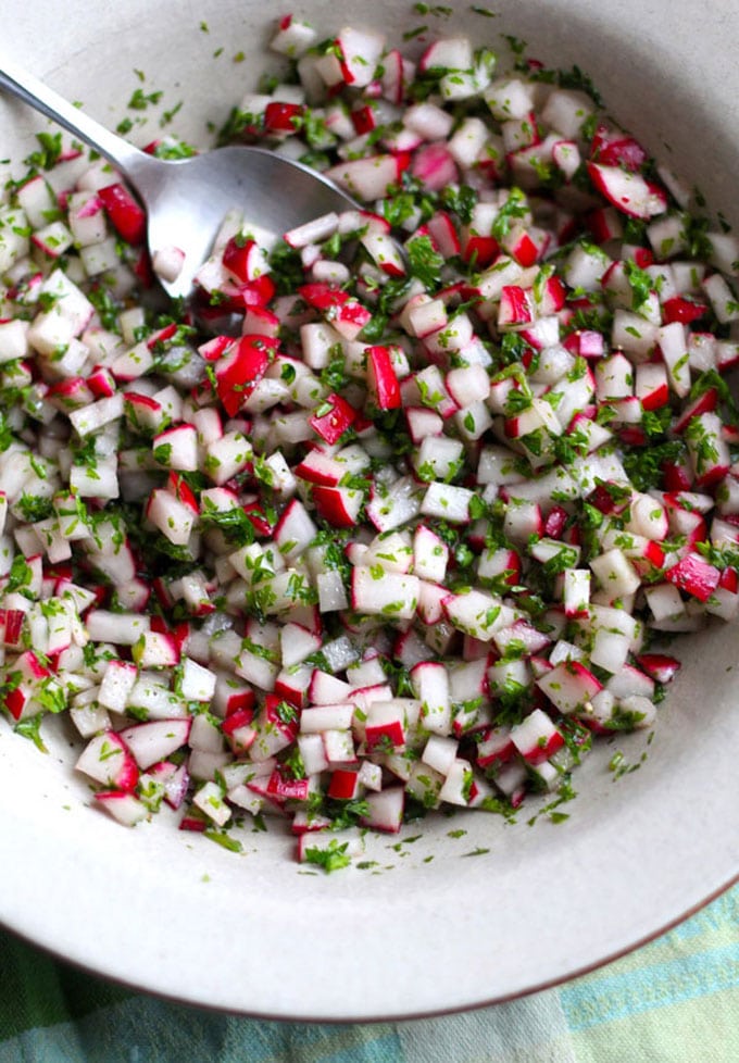 chopped radish salad in a white bowl - These radish recipes are simple and delicious (and best of all, they'll make you actually WANT to eat your veggies!) Give them a try for a colorfully peppery crunch.
