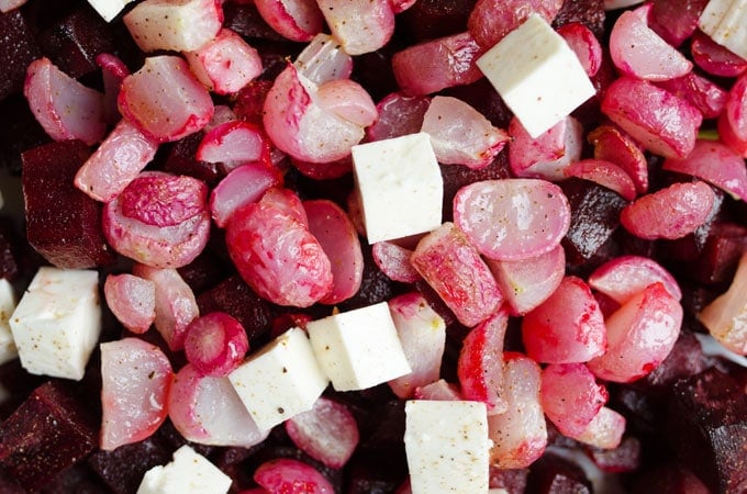 Close-up of roasted beets and radishes with feta cheese - Here's a way to make your beets NOT taste like dirt! This Roasted Beet an Radish Salad is loaded with fresh pesto, feta cheese, and a hint of lemon, which help to counter that typical beet taste that so many of us can't get over.