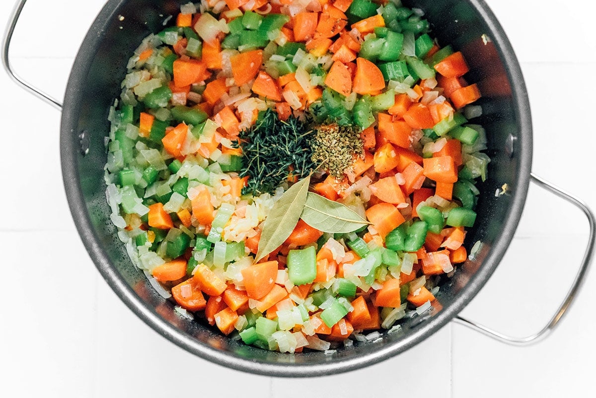 A pot filled with veggie quinoa soup ingredients