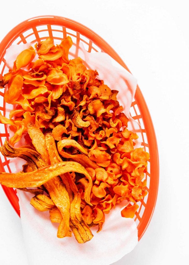 Carrot chips in a basket on a white background
