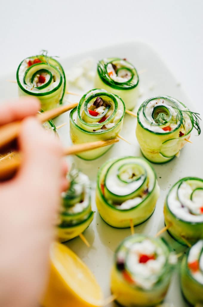 Picking up rolled up cucumber sushi rolls with chopsticks