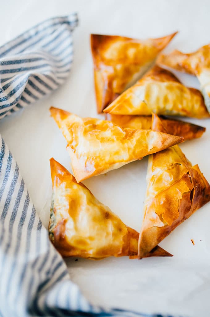 These Spanakopita Triangles are a simple appetizer jam-packed with feta and spinach, wrapped up in buttery, flaky phyllo crust.