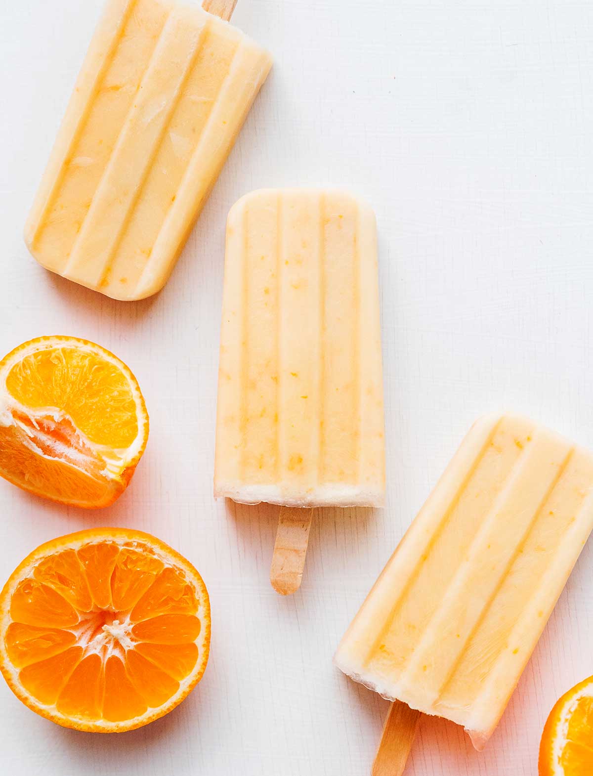 Orange creamsicles with orange fruit on a white background