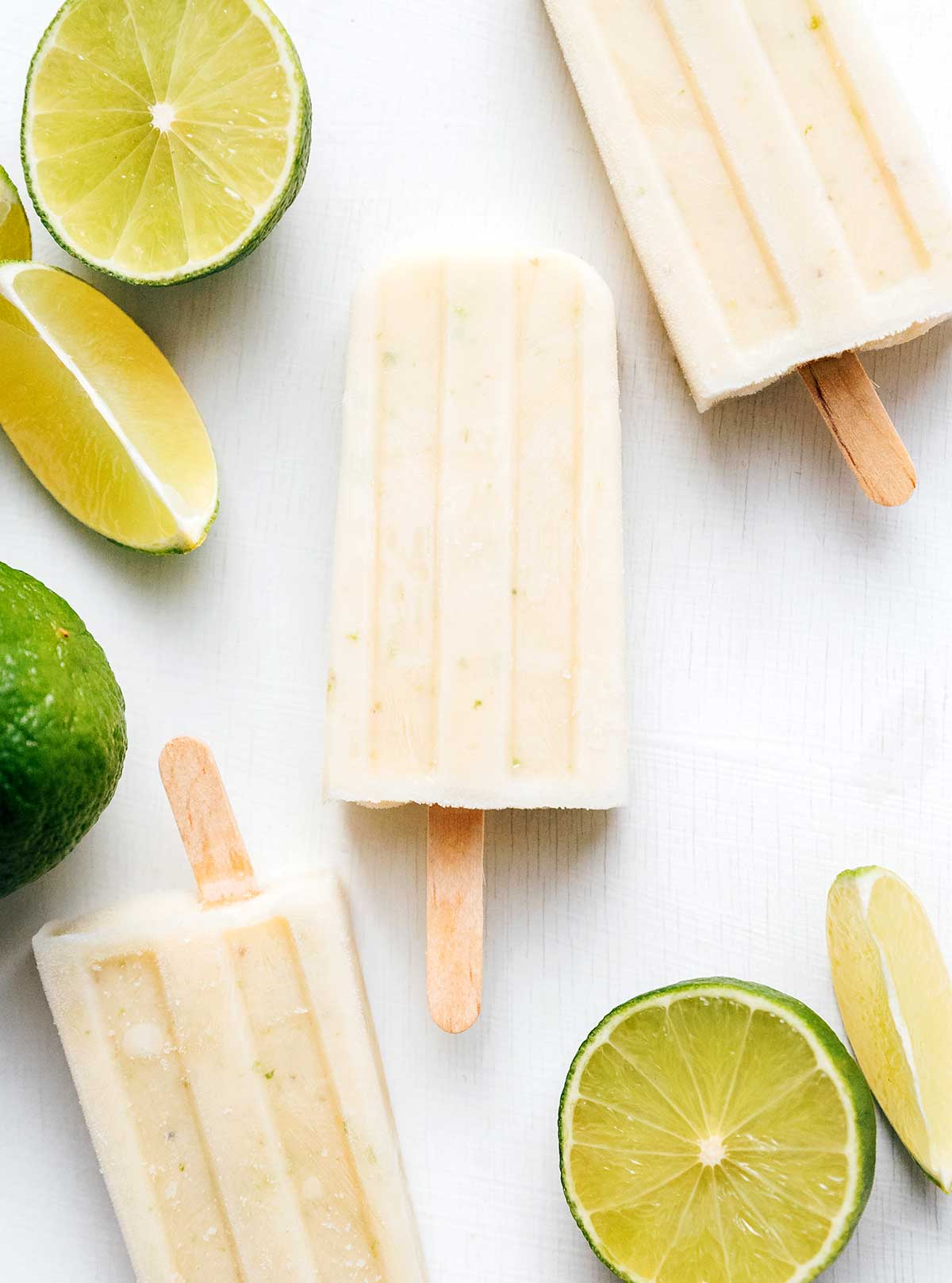 Lime creamsicles with lime fruit on a white background