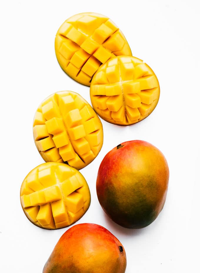 Cut mangoes on a white background