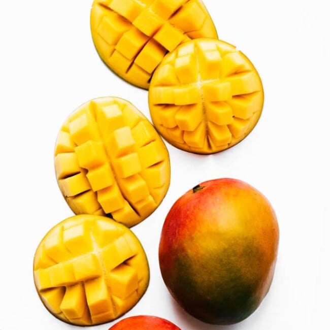 Cut mangoes on a white background