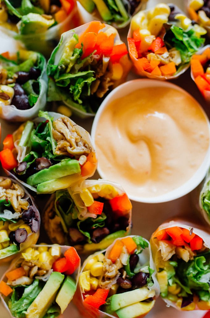 Closeup of spring rolls - These vegetarian Southwest Spring Rolls are packed with fresh vegetables and dipped in a smoky chipotle sauce. You’ll forget how healthy they are as you devour the whole pile!