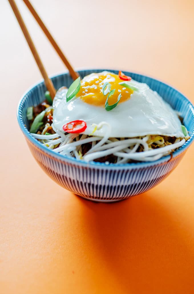 Egg roll bowl on orange background in blue striped bowl - This Vegetarian Egg Roll in a Bowl is the laid back egg roll you didn't know you needed. It has all the tasty fillings found in your favorite egg rolls, subbing out the pork for pulled oyster mushrooms!