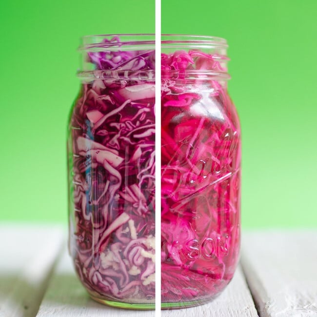 Pickled red cabbage in a glass jar with a green background.