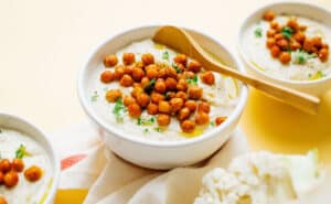 Cauliflower soup with chickpeas in 3 bowls.