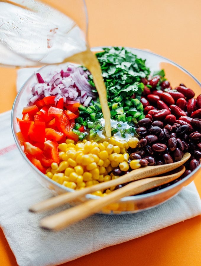 bean salad recipe in a bowl with dressing being poured in