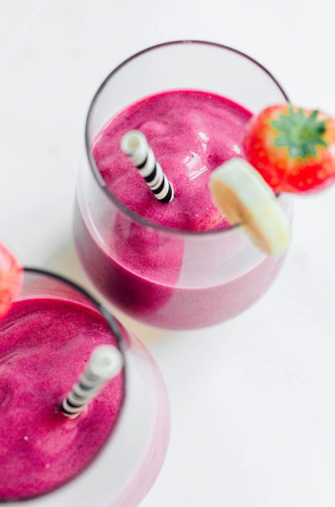 Bright pink smoothie with beets and strawberry on a white background