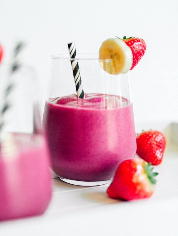 Bright pink smoothie with beets and strawberry on a white background
