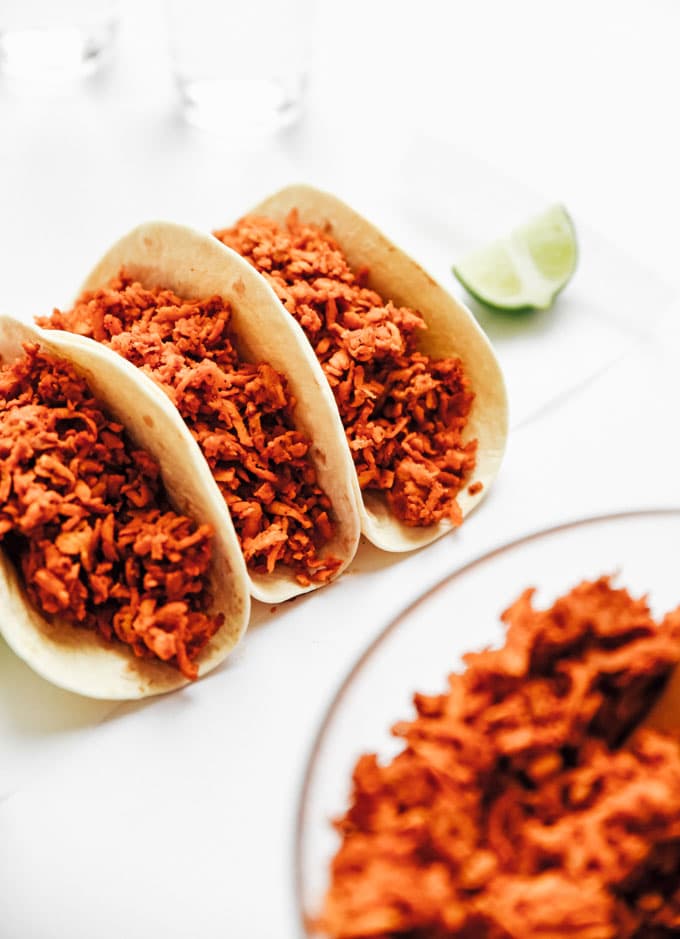 Vegan tempeh taco meat in taco shell on white background