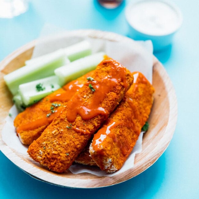 These Buffalo Tempeh Tenders are baked to crispy perfection and slathered in buffalo sauce to make the most addictive vegetarian comfort food!
