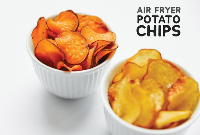 Homemade air fried sweet potato chips on a white background - The ultimate guide on how to cook air fryer potatoes! How to make roasted potatoes, homemade French fries, and potato chips in your air fryer, using both white potatoes and sweet potatoes.