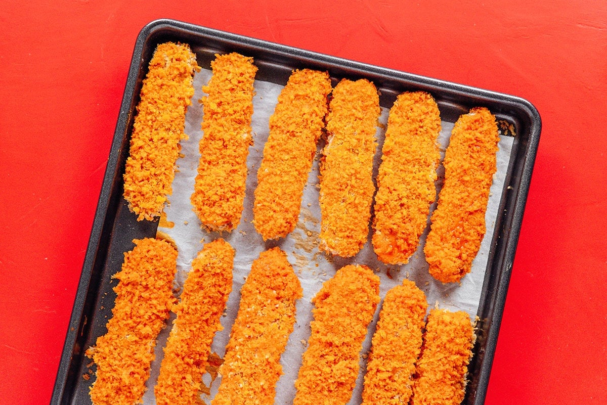 Red tempeh tenders on a baking sheet