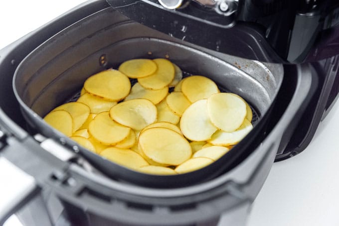 Making potato chips in an air fryer on a white background