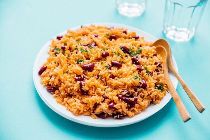 Spanish rice and red beans on a plate with a blue background - This easy vegan Spanish Rice and Beans recipe is quick to whip up and is a great source of complete proteins!