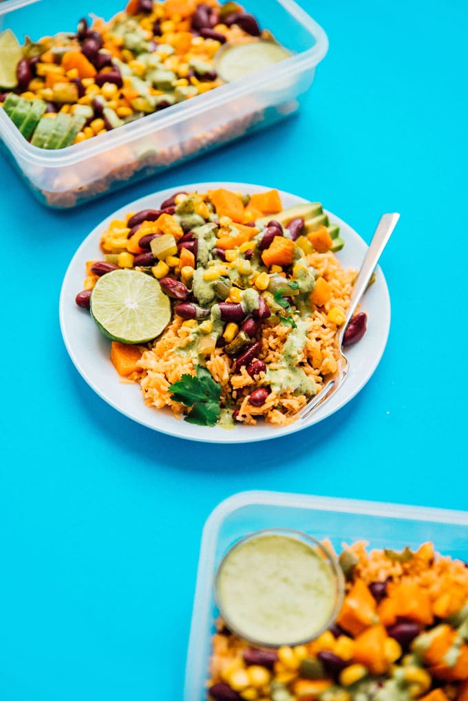 Meal prep on a blue background - Serving up some easy vegetarian meal prep today in the form of roasted veggies with Spanish rice, tossed in a creamy cilantro dressing!