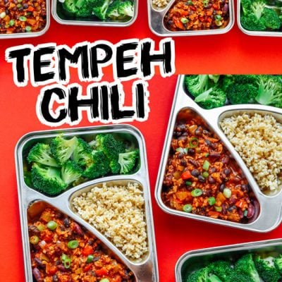 Meal prep containers with broccoli, chili, and bulgur on a red background - This vegan Tempeh Chili Meal Prep is ready in 30 minutes and takes care of lunch for the week (plus it's like...really tasty).